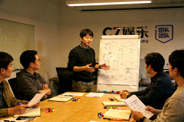 C7娱乐团队早期创业讨论会议场景，白板上画着产品草图